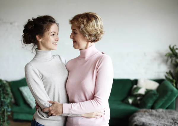 Lebensstil, Familien- und Personenkonzept: Glückliche junge Frau und ihre Mutter zu Hause — Stockfoto