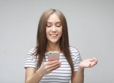  mutlu heyecanlı kadın metin mesajı almak için memnun, cep telefonu bakıyor