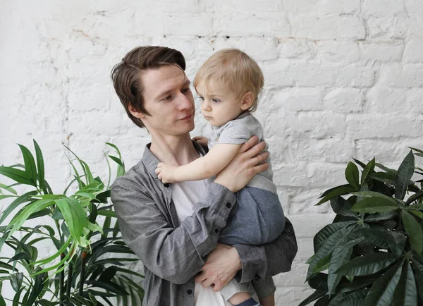 Estilo de vida, família e conceito de pessoas - Pai jovem feliz com seu filho de um ano de idade brincando em casa — Fotografia de Stock