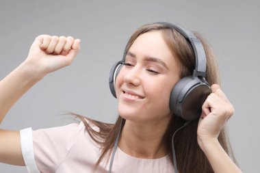 Kulaklıklı genç bir kadın müzik dinliyor.