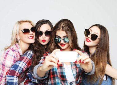 Akıllı telefonlu mutlu genç kızlar selfie çekiyor.