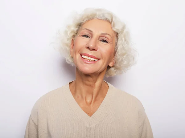 Estilo de vida, la emoción y el concepto de la gente: Primer plano retrato de la mujer mayor feliz sonriendo —  Fotos de Stock