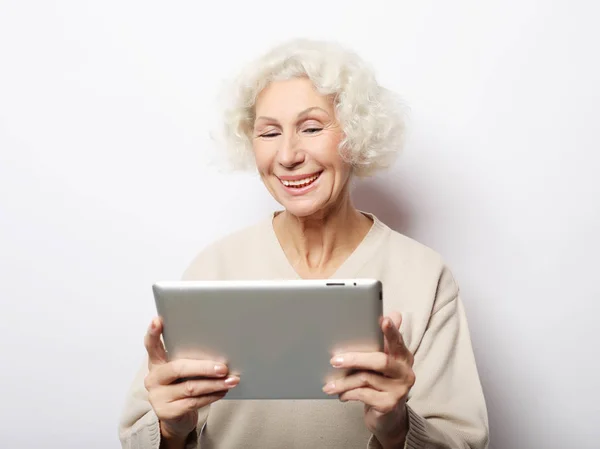 Livsstil, teknik och människor koncept: lycklig mogen kvinna med hjälp av en tablett — Stockfoto