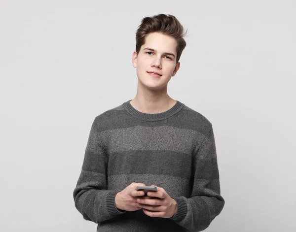 Happy young man typing sms on white background — Stock Photo, Image