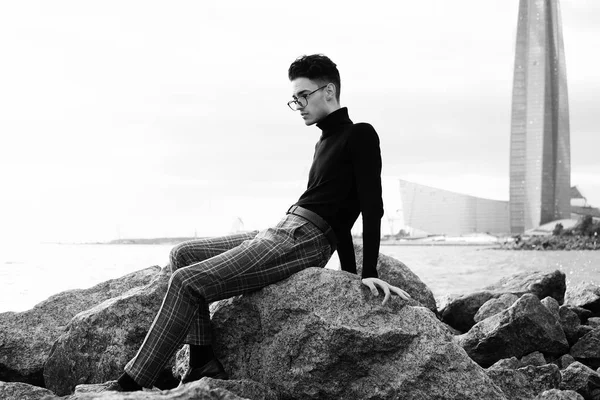 유행 젊은이 바다 근처 바위에 앉아 — 스톡 사진