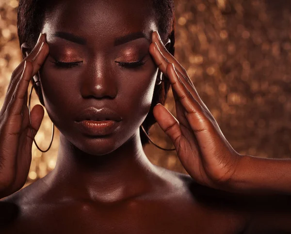 Fashion studio portrait of an extraordinary beautiful african american model with closed eyes  over golden background — Stock Photo, Image