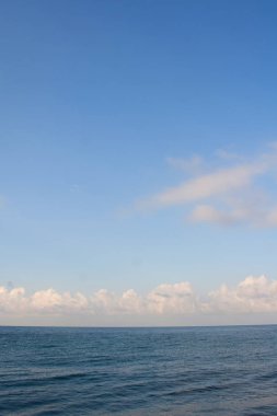 Bulutlar ile koyu mavi deniz ve açık mavi gökyüzü