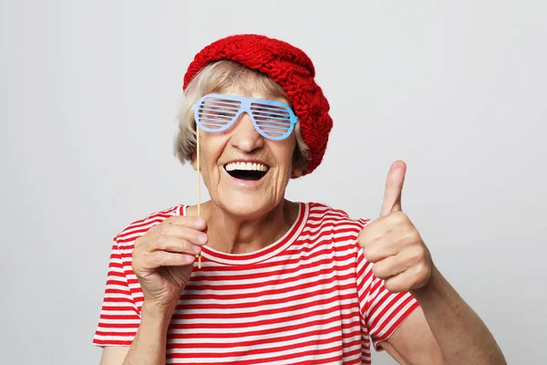 Yaşam tarzı, duygu ve insan konsepti: sahte gözlüklü komik büyükanne, kahkahalar ve partiye hazır — Stok fotoğraf