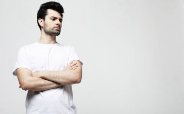 Akıllı rahat giyim yakışıklı genç esmer adam kamera bakarak, beyaz arka plan üzerinde