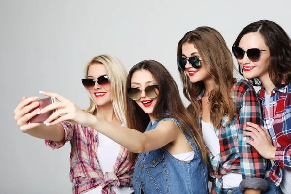Cuatro chicas adolescentes felices con teléfono inteligente tomando selfie — Foto de Stock
