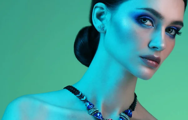 Portret van mooie sexy meisje dragen sieraden met trendy make-up op kleurrijke levendige achtergrond — Stockfoto