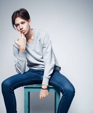 Moda ve insan kavramı: gri arka plan üzerinde poz rahat giysiler giymiş şık trendy genç adam
