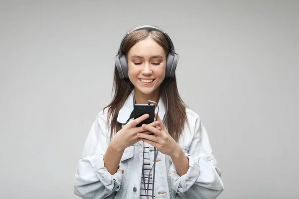 Belle jeune femme à l'écoute de la musique dans les écouteurs avec smartphone — Photo