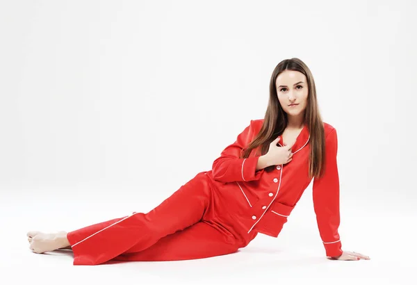 Estilo de vida, moda e conceito de pessoas - linda garota morena vestida com pijama vermelho sobre fundo branco — Fotografia de Stock