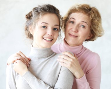 Yaşam tarzı, aile ve insan konsepti: Mutlu genç kadın ve annesi evde, mutlu aile