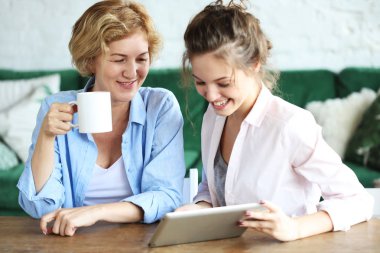 Yaşam tarzı, tehnoloji ve insan konsepti: tablet bilgisayar kullanan anne ve yetişkin kız