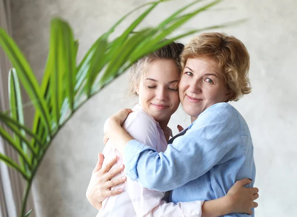 Lifestyle, family and people concept: Ευτυχισμένη νεαρή γυναίκα και η μητέρα της στο σπίτι, ευτυχισμένη οικογένεια — Φωτογραφία Αρχείου