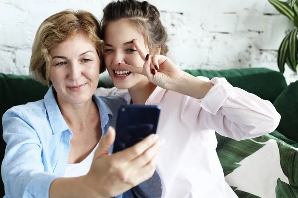 生活方式,毒理学和人的概念:成熟的母亲和她的女儿使用智能手机自拍 — 图库照片