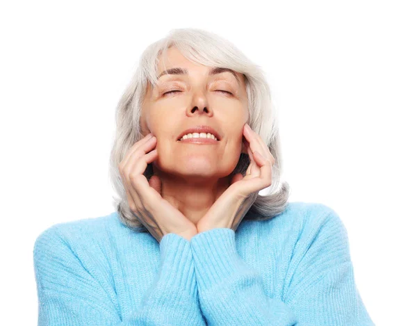 Estilo de vida y el concepto de la gente: Primer plano retrato de la mujer mayor feliz soñando con los ojos cerrados sobre fondo blanco —  Fotos de Stock