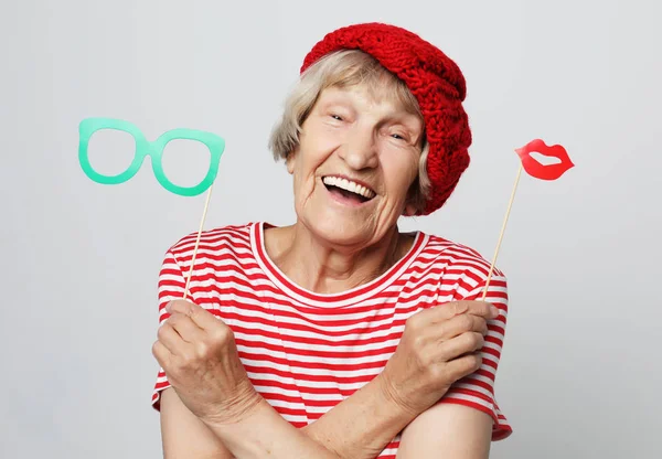 Estilo de vida, la gente y el concepto de fiesta: abuela divertida con ropa roja lista para la fiesta — Foto de Stock