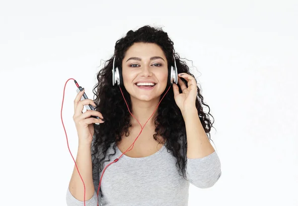 Estilo de vida, la tecnología y el concepto de la gente: Hermosa mujer joven escuchando música en los auriculares —  Fotos de Stock