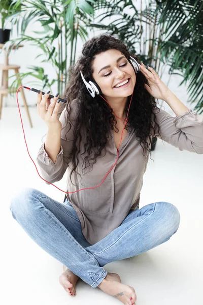 Τρόπος ζωής, την τεχνολογία και τους ανθρώπους έννοια: όμορφη νεαρή γυναίκα ακούγοντας μουσική στα ακουστικά — Φωτογραφία Αρχείου