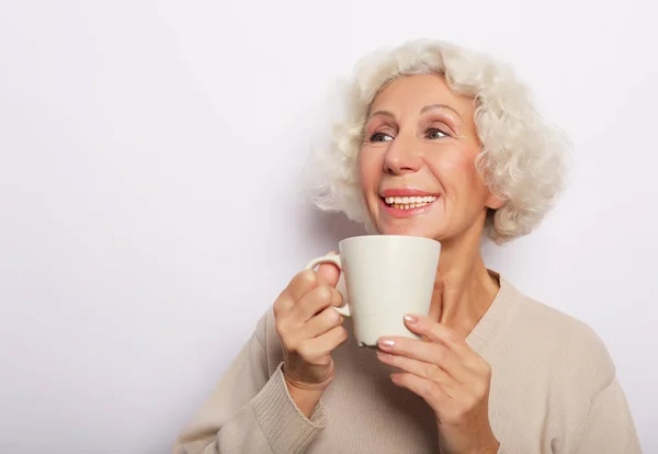 Idade animado senhora sorrindo rindo, segurando xícara beber café, chá, sobre fundo branco — Fotografia de Stock