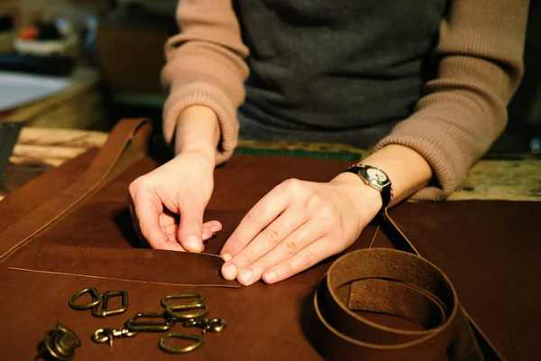 Giovane donna bruna lavora in uno studio di produzione di borse, ritaglia i dettagli — Foto Stock