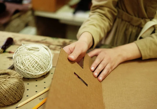 Молодая женщина складывает коробку в швейной мастерской — стоковое фото