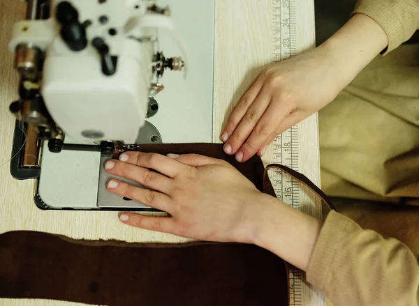 Closeup on young woman sewing leather handbag — Stock Photo, Image