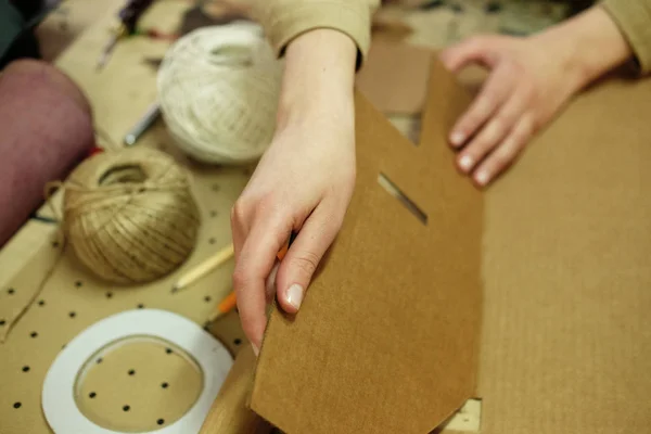 Jonge vrouw vouwt verpakking doos in naaiatelier — Stockfoto