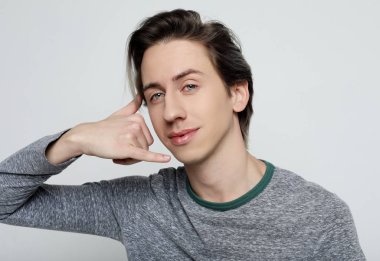  Genç çekici adam telefon işareti yapıyor.