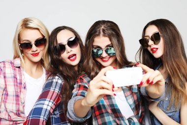 Akıllı telefonlu mutlu genç kızlar selfie çekiyor.