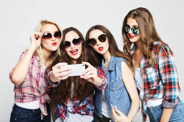 Cuatro chicas adolescentes felices con teléfono inteligente tomando selfie — Foto de Stock