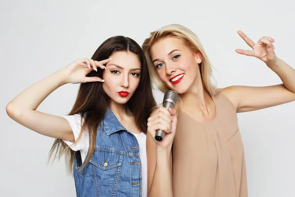 Beauty girls with a microphone singing and having fun together — Stock Photo, Image