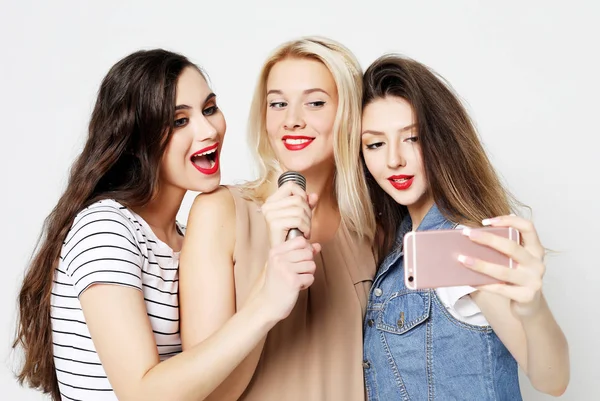 Meninas de beleza com um microfone cantando e se divertindo juntos — Fotografia de Stock