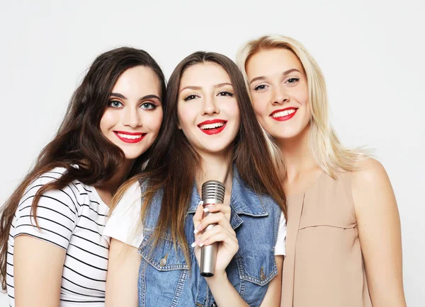 Beauty girls with a microphone singing and having fun together — Stock Photo, Image