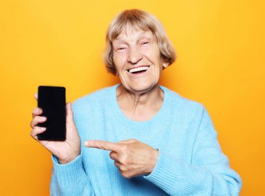 Yeni akıllı telefonlu olgun bir kadının resmi..