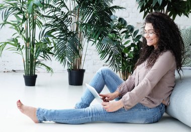 Yaşam tarzı, teknoloji ve insan konsepti - Evde dijital tablet kullanan çekici bir genç kadının portresi