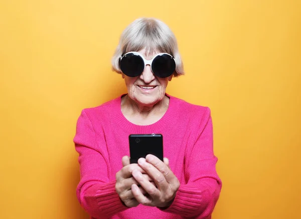 Stile di vita, famiglia e persone concetto: vecchia nonna sta parlando con i suoi nipoti per telefono . — Foto Stock