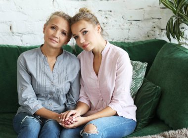 Yaşam tarzı, aile ve insan konsepti: Mutlu genç kadın ve annesi evde, mutlu aile