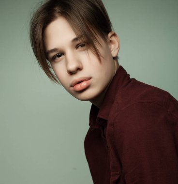 Stüdyoda poz veren çekici genç çocuk.