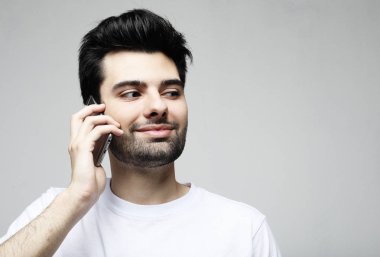 Gri arka plan üzerinden telefonda konuşan şık adam Portresi