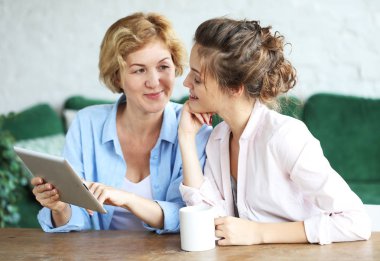 yaşam tarzı, teknoloji ve insan kavramı: evde tablet bilgisayar kullanarak anne ve yetişkin kızı