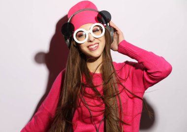 Kulaklık güzel genç kadın gri bir arka planda ayakta müzik dinleme