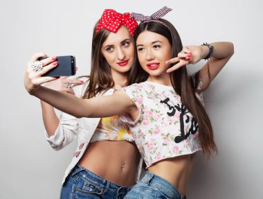 teknoloji, dostluk ve insan kavramı-iki gülümseyen gençler Smartphone ile resim çekmek