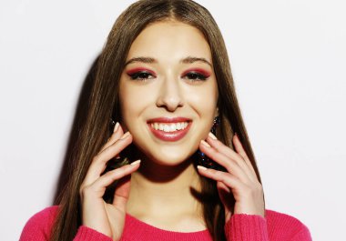 yaşam tarzı, güzellik ve insan kavramı: Genç Sevimli gülümseyen kız pembe kazak giyiyor