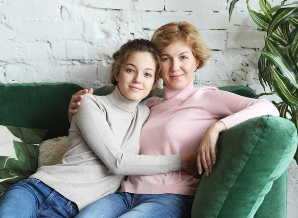 Lifestyle- und People-Konzept - schöne Seniorin und ihre erwachsene Tochter umarmen sich, blicken in die Kamera und lächeln. — Stockfoto