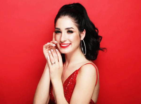 Estilo de vida, fiesta y concepto de personas - mujer de lujo en vestido de noche posando sobre fondo rojo — Foto de Stock