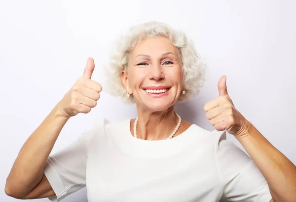 Životní styl, emoce a lidé koncept: Starší šťastná žena dává palec nahoru a dívá se do kamery — Stock fotografie